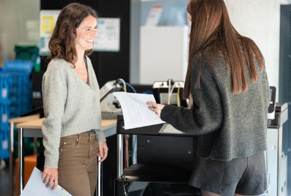 2 jeunnes femmes en face des imprimantes